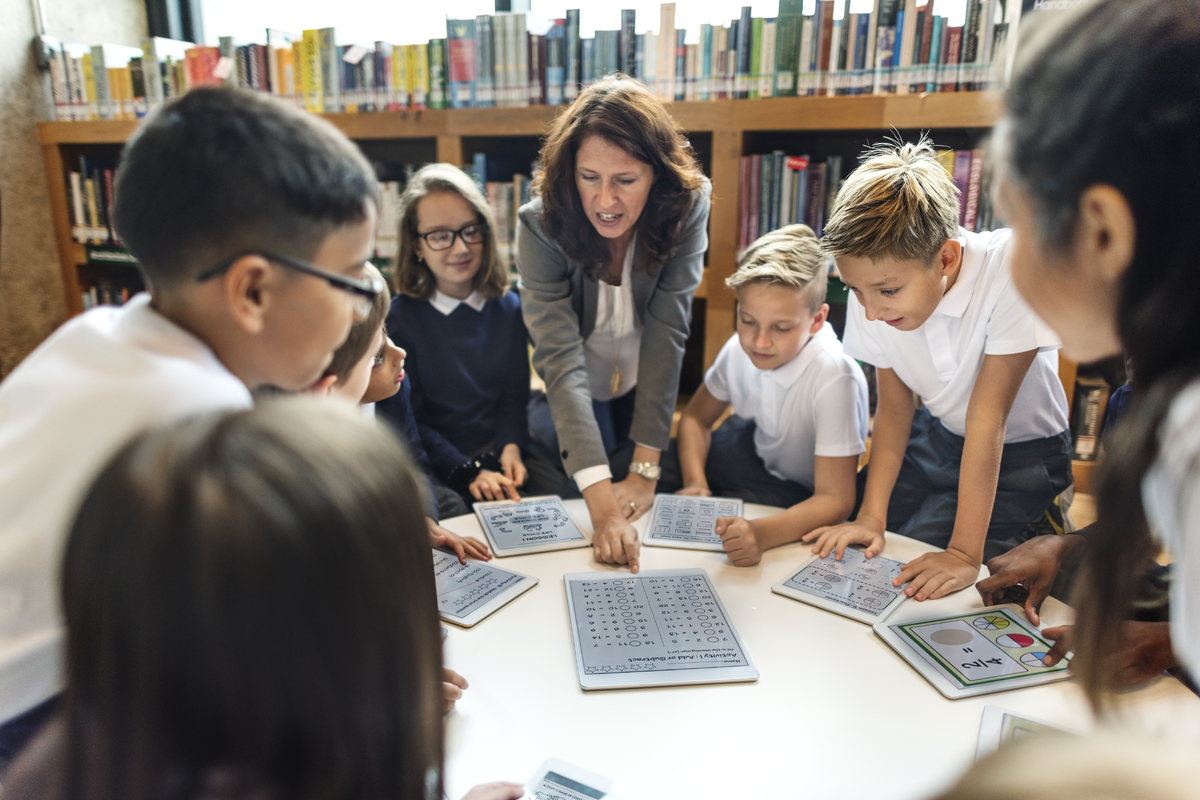 teacher giving kids instructions on tablet