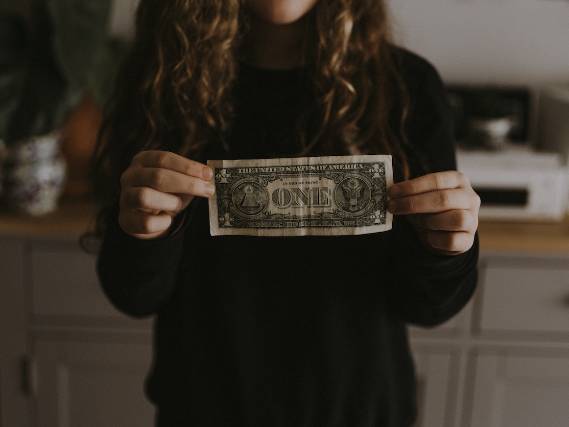 woman holding a dollar bill