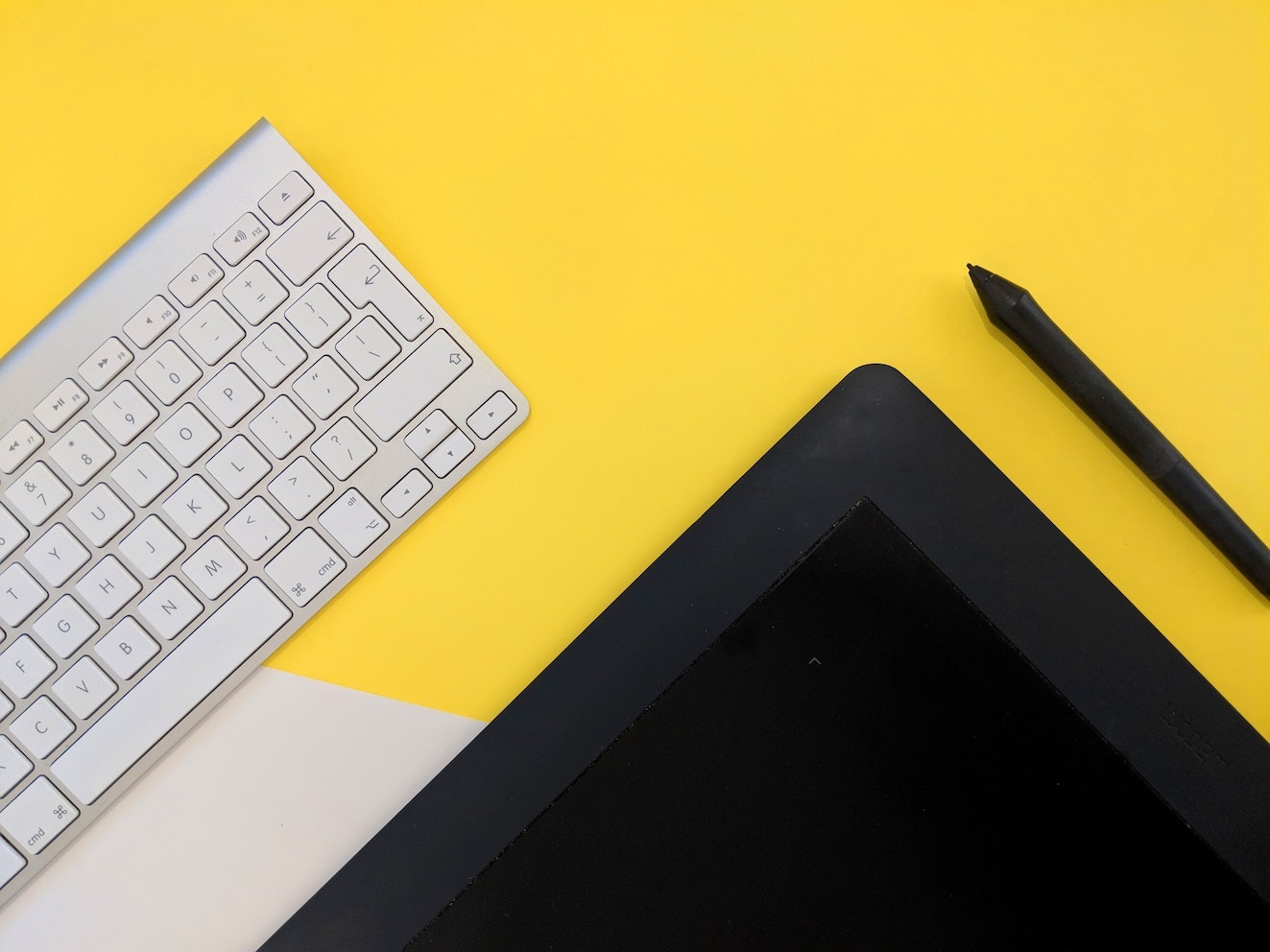 a keyboard and a tablet on a yellow background
