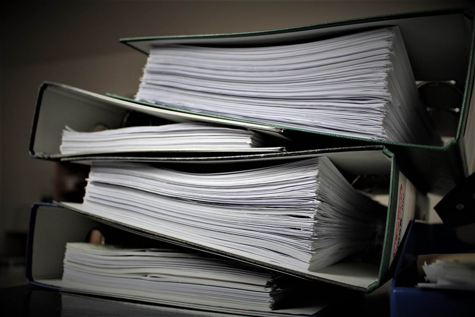 A stack of files sits in binders on a table
