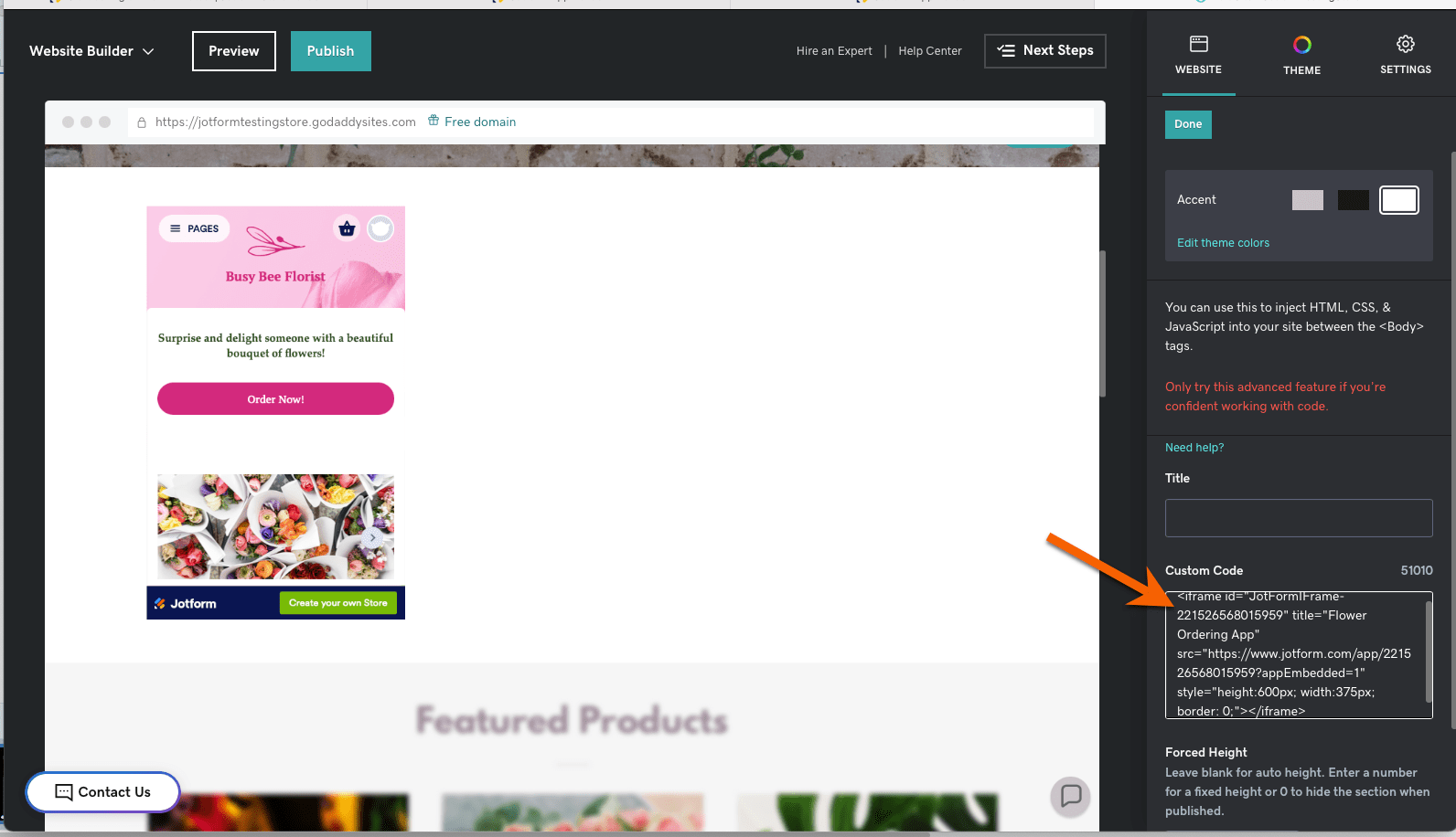 Screenshot of GoDaddy's site builder with HTML code pasted into the custom code text box