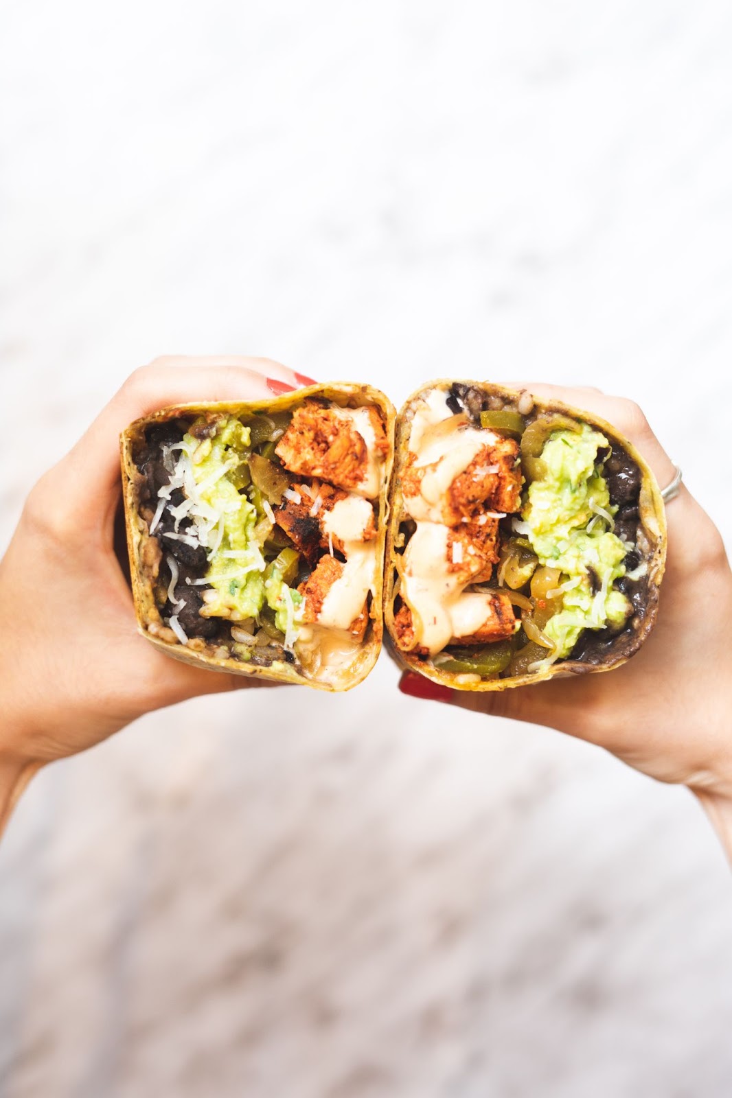 close up shot of a person holding burrito