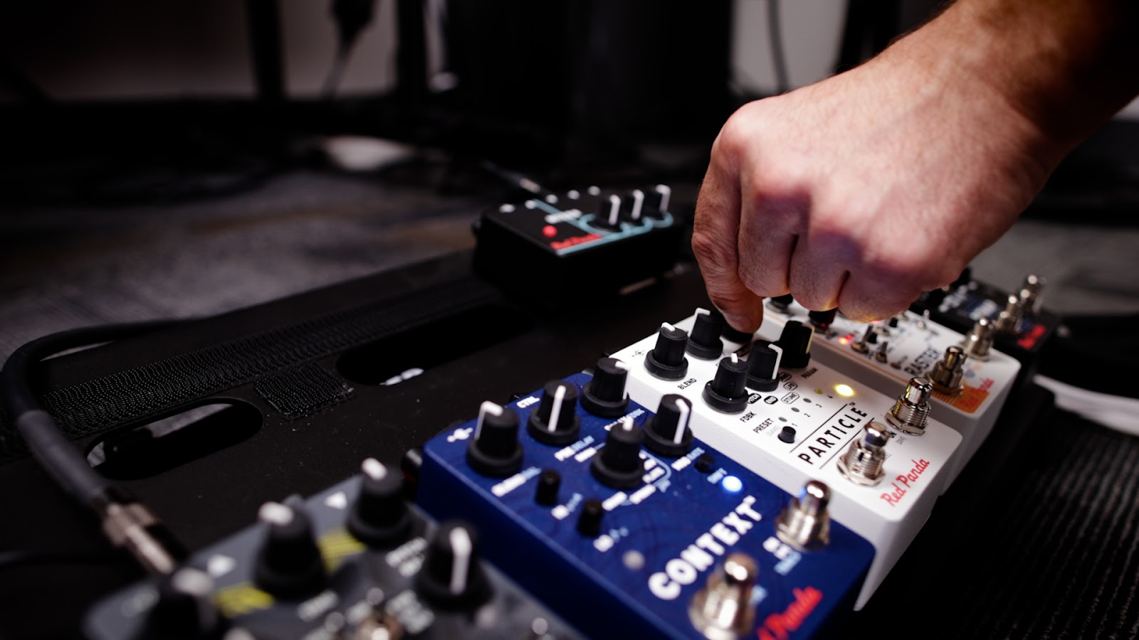 A person playing a guitar pedal, creating modified sound with their feet
