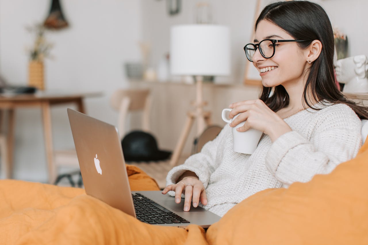 Frau trinkt Kaffee und benutzt einen Laptop