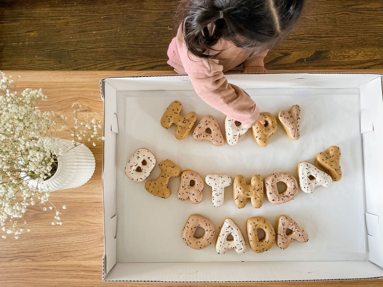 Photo of the daughter of a Letterbox Doughnuts client with a birthday arrangement
