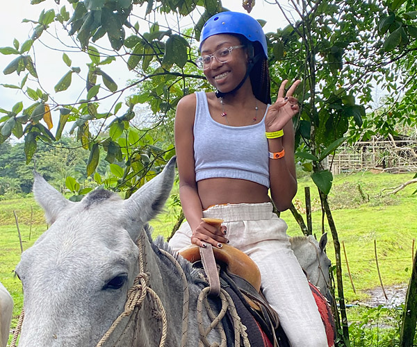 Image of a young girl riding a horse outdoors