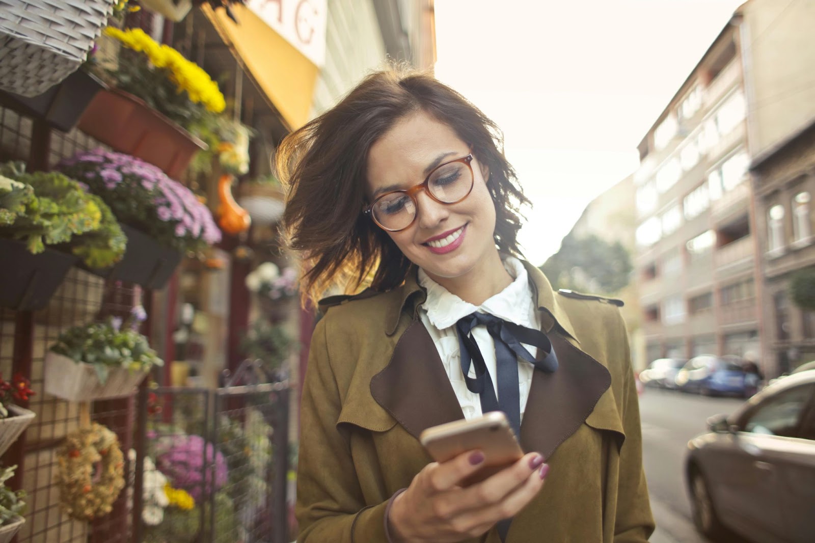 A Woman Beside Flower Shop Using Smartphone