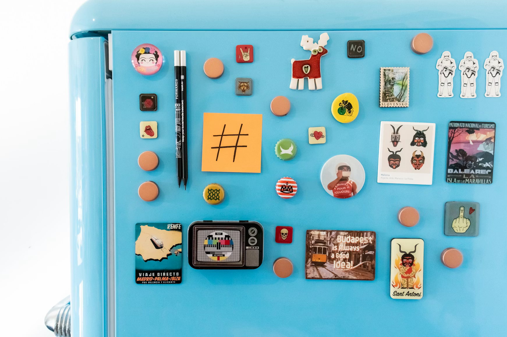 Decorative magnets arranged on a blue refrigerator door