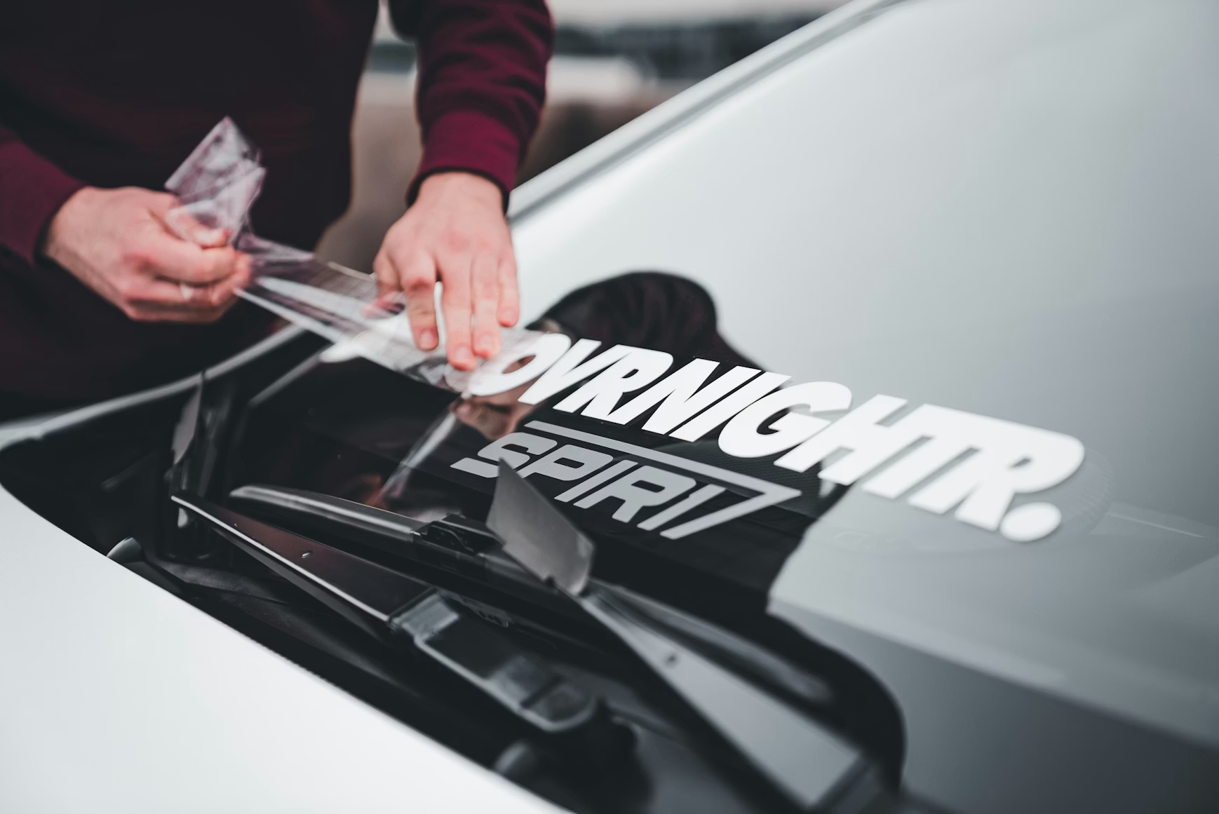 Vinyl decal being applied to a car window